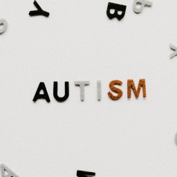 Photo of colorful letters lined up to form 'Autism' word, surrounded by scattered letters