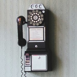 Photo of three vintage telephones on a wall